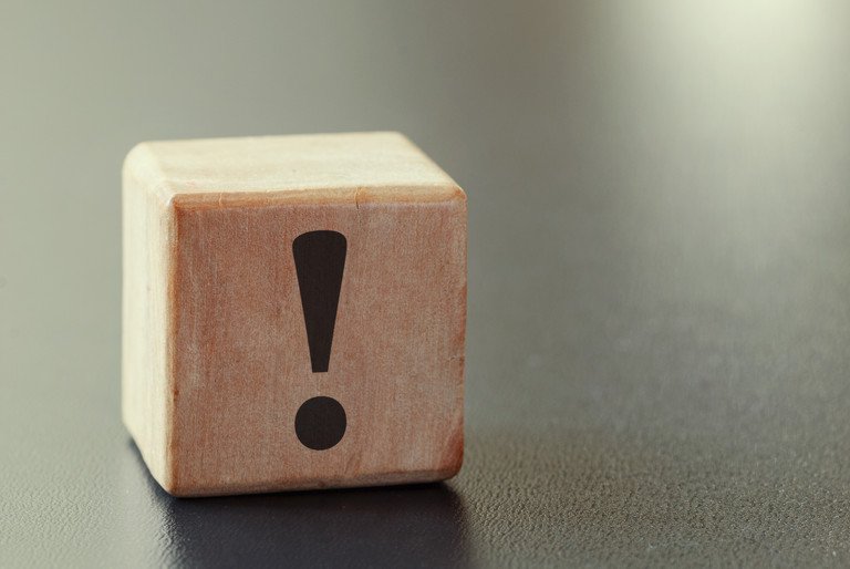 Symbolbild f&uuml;r eine wichtige Information, dargestellt durch einen Holzw&uuml;rfel auf dem ein schwarzes Ausrufezeichen zu sehen ist