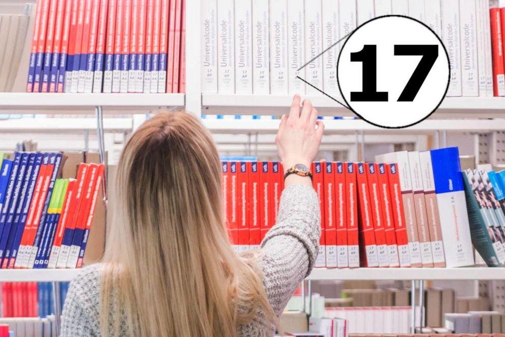 Studentin vor Lehrbuchsammlung mit Signaturbeginn "17"