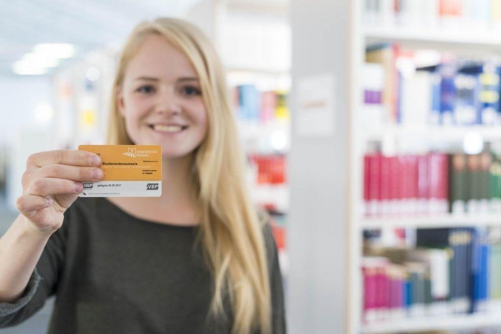 Studentin mit Campuscard in der Bibliothek